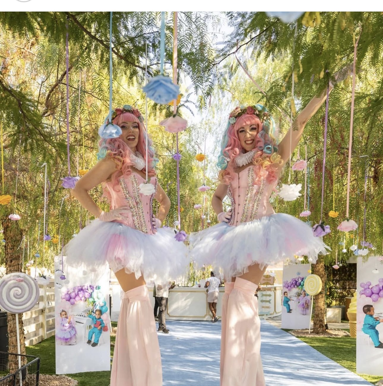 Pastel stilt walkers at a garden celebration
